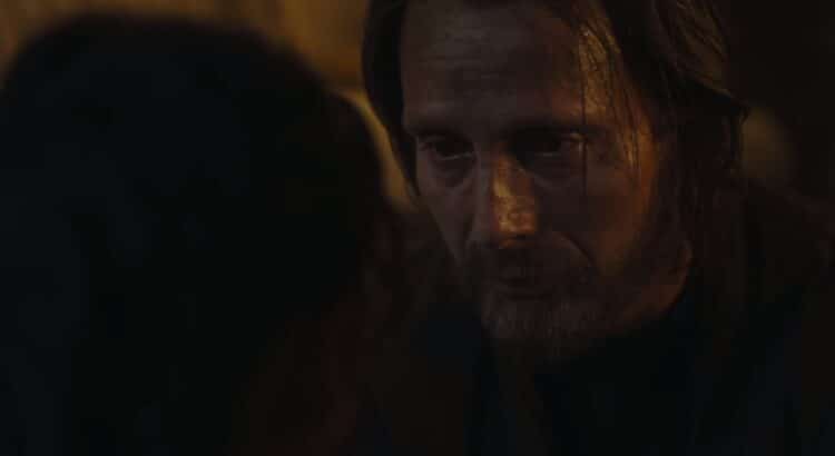 Two men having an intense conversation in dim lighting.