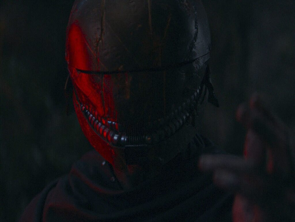 Red lit eerie helmet in dark, mysterious setting