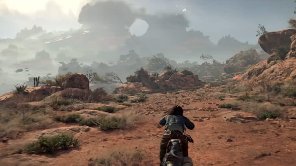 Motorcyclist riding through rugged desert landscape