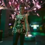 Meredith Stout in leather straps standing under cherry blossom lights