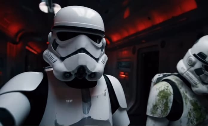Two stormtroopers inside a dark corridor with red emergency lighting