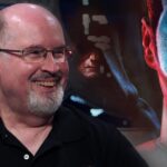 Timothy Zahn smiling with artwork of Grand Admiral Thrawn in the background, celebrating the Star Wars author’s birthday.