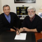 Disney CEO and filmmaker signing the Lucasfilm acquisition deal in 2012