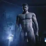 Modded nude Chris Redfield model in Resident Evil Village standing in dramatic blue lighting.