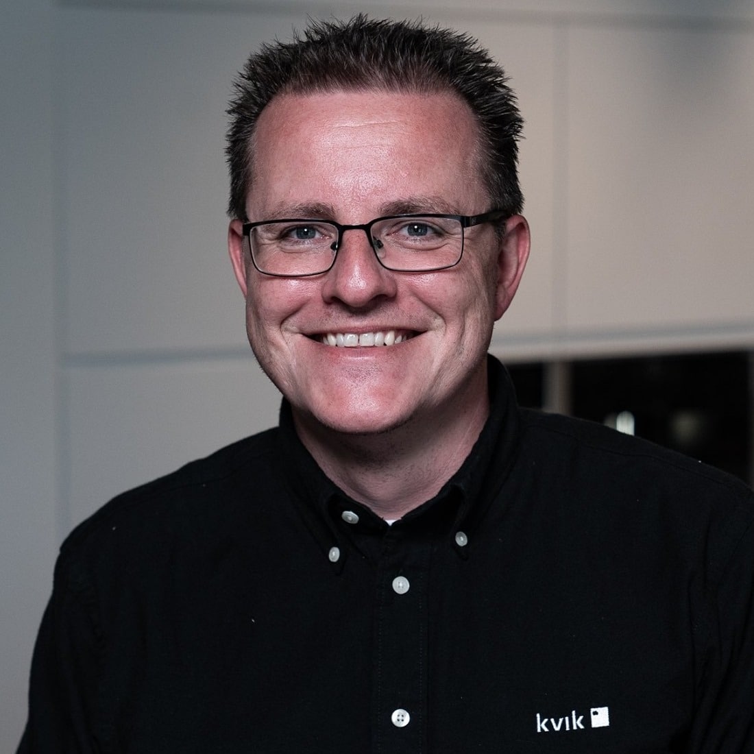 Smiling man wearing glasses and black shirt